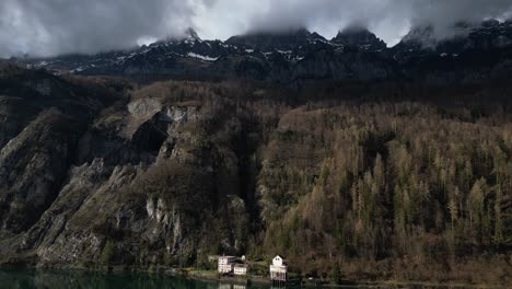 Backward-aerial-shot-of-Alps-in-Walensee,-Switzerland