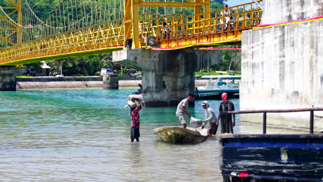 Seetang-Anbau---Seetang-Bauern-Tragen-Säcke-Mit-Geerntetem-Seetang-Vom-Boot-In-Nusa-Lembongan