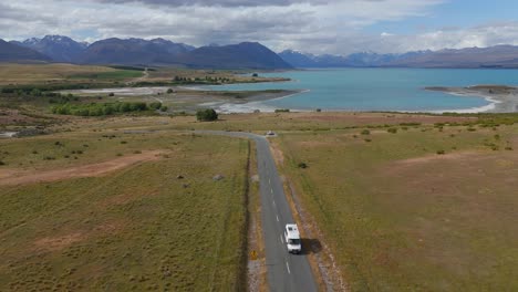 Establishing-drone-shot-of-camper-van-on-road-near-Lake-Tekapo-in-New-Zealand