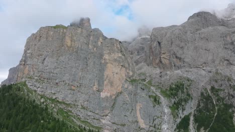 Cinematic-aerial-footage-of-a-drone-ascending-towards-the-Selva-rugged-mountain-range-near-Passo-Gardena,-Dolomites