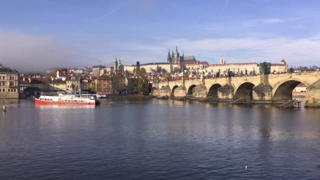 Vltava-river,-Prague-Castle,-Charles-Bridge-and-cruise-ship-in-Czech-Republic-in-autumn-weather