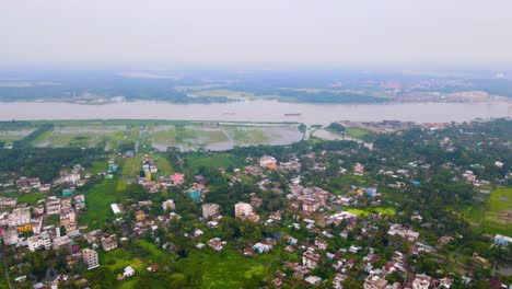 Aerial-forward-city-Barisal,-Bangladesh-and-river-Kirtankhola,-cloudy-day