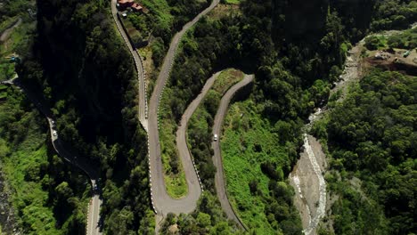 Imágenes-De-Drones-De-Una-Carretera-Empinada-Y-Con-Curvas-En-Las-Montañas-Verdes-En-Un-Día-Soleado