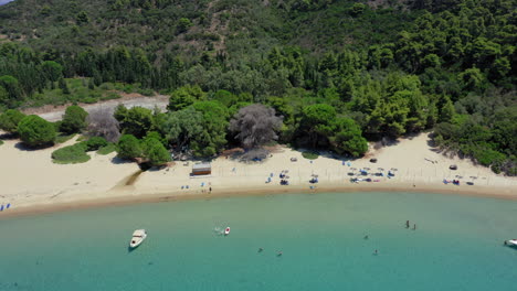 Aerial:-Drone-shot-of-a-beach-in-Tsougria-island-near-Skiathos,-Sporades,-Greece-with-amazing-turquoise-and-emerald-crystal-clear-water