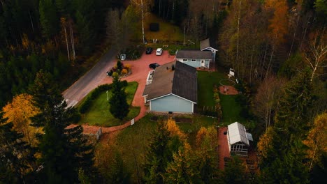 Aerial-view-circling-detached-house-in-middle-of-vibrant,-fall-foliage-forest