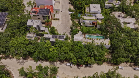 Tulum-Mexico-Aerial-v1-birds-eye-view-drone-flyover-luxury-neighborhood-capturing-buildings-in-the-area,-tilt-up-reveals-nature-landscape-on-a-sunny-day---Shot-with-Mavic-3-Pro-Cine---July-2023