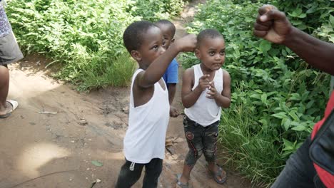 Three-young-playful-Tanzania-village-children-fist-bump-greeting-passing-people