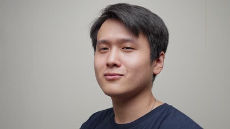 Southeast-asian-man-wears-black-sun-sunglasses-taking-them-off-smiling-to-camera-Portrait-shot-at-studio-indoors