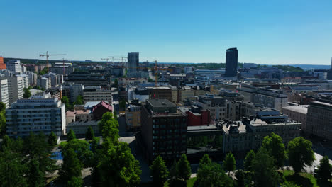 Aerial-tracking-shot-over-the-cityscape-of-Tampere,-sunny,-summer-day-in-Finland