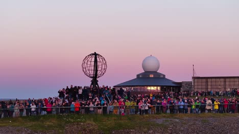 Nordkap,-Norwegen,-Drohnenaufnahme-Einer-Touristenmenge-Rund-Um-Das-Globus-Denkmal-Nach-Sonnenuntergang,-60 fps