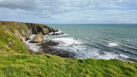 Seascape-Marea-Entrante-Gran-Seastack-Y-Exuberante-Hierba-Verde-En-El-Borde-Del-Acantilado-Costa-De-Cobre-Waterford-Irlanda-En-Una-Tarde-De-Primavera-En-Abril