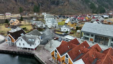White-tourist-bus-arriving-Mo-Modalen,-aerial-moving-backwards-revealing-town-center-and-seafront