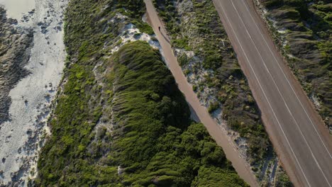 Ciclista-Corriendo-Por-El-Carril-Bici-En-El-Acantilado-Entre-La-Playa-Y-La-Carretera