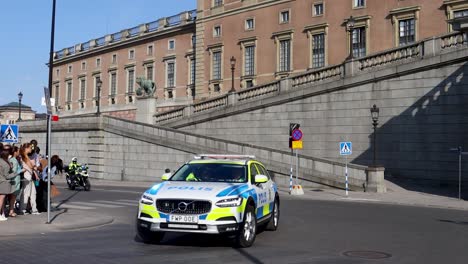 Móvil-Policial-Y-Motocicleta-Escoltando-En-El-Desfile-Del-Rey-Y-La-Reina-Por-El-Palacio-De-Estocolmo-En-Suecia,-Cámara-Lenta