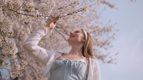 Feliz-Retrato-De-Una-Mujer-Joven-En-El-Parque-Forestal-Ciudadano-De-Yangjae-Con-Flores-De-Sakura-En-Flor-En-El-Distrito-De-Seocho,-Ciudad-De-Seúl,-Corea-Del-Sur