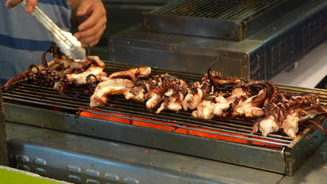 Persona-Asando-Trozos-De-Calamares-En-El-Mercado-Callejero