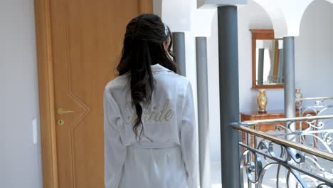 A-newlywed-on-the-morning-of-his-wedding,-walks-through-the-corridors-of-her-home,-she-is-dressed-in-a-bride's-bathrobe
