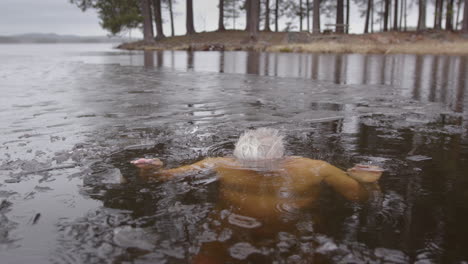 Slomo-shot-of-a-man-in-his-late-50s-dipping-his-head-under-the-icy-lakewater
