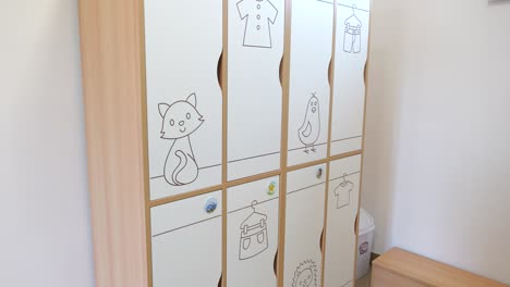 Storage-shelf-with-cabinets-decorated-with-cute-sketches-in-kindergarten-classroom