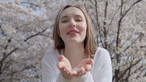 Kaukasische-Frau-Bläst-Kirschblütenblätter-In-Ihren-Händen