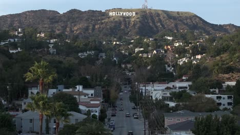 Iconic-Hollywood-sign-from-Beachwood-Drive-over-neighborhood,-aerial-rising