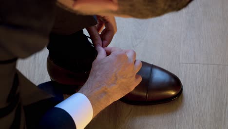 Ein-Mann-Im-Anzug-Bindet-Die-Schnürsenkel-Seiner-Luxuriösen-Schwarzen-Schuhe