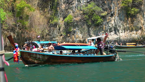 Tourists-taking-pictures-on-long-tail-boat-in-Phi-Phi-islands