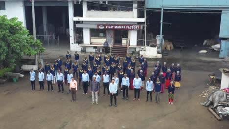 aerial-drone-view-The-drone-camera-is-moving-towards-the-right-side-showing-the-outlet-of-a-large-factory-and-their-supervisor-manager-and-their-workers-with-their-dress-code