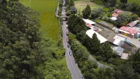 Desde-Arriba,-La-Tranquila-Elegancia-De-Los-Automóviles-Deslizándose-Por-Carreteras-Iluminadas-Por-El-Sol-Rodeadas-De-Vegetación,-Una-Cautivadora-Vista-Desde-Un-Dron-De-La-Naturaleza-En-Movimiento.