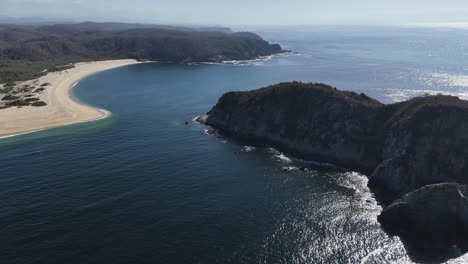 Drone-reveals-panoramic-view-of-Cacaluta-Bay-and-rocky-island,-Huatulco,-Oaxaca,-Mexico