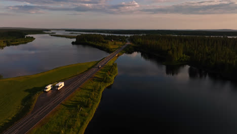 Aerial-view-following-a-car-driving-on-the-road-E75,-summer-sunset-in-Lapland
