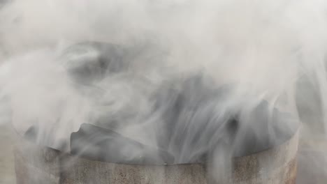 Close-up-of-a-charcoal-chimney-starter-with-a-lot-of-smoke