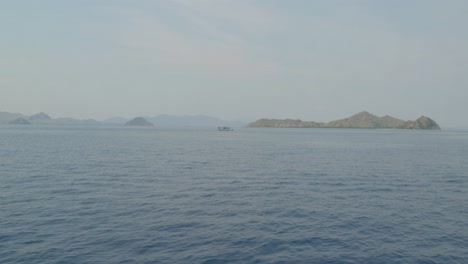 Remote,-uninhabited-island-nestled-within-Komodo-National-Park-and-a-small-boat,-Indonesia