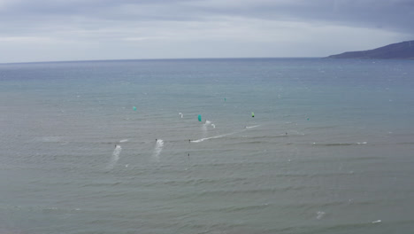 Wide-aerial-view-of-wind-surfers-surfing-the-waves-of-Maalaea-Bay-on-Maui,-Hawaii