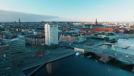 moving-drone-shot-of-the-downtown-skyline-of-copenhagen-in-Denmark-at-the-river-Tryggevælde-with-a-bridge-in-the-right-corner