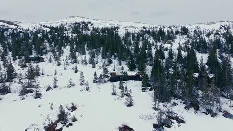 Flug-In-Richtung-Holzhütte-Auf-Schneebedeckten-Berg-In-Verran,-Norwegen
