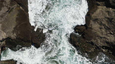 Descendiendo-Cerca-De-Las-Espumosas-Aguas-Blancas-De-Las-Olas-Rompiendo-Contra-Las-Rocas