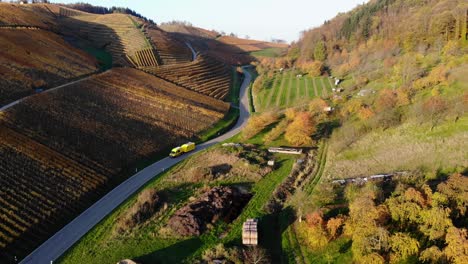 Transporter-with-trailer-drives-through-vineyards-that-glow-in-colorful-autumn-colors