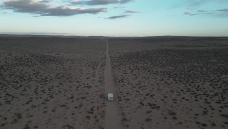An-aerial-view-captures-a-white-camper-truck-traversing-the-desert-terrain,-located-south-of-Salt-Lake-City,-Utah,-USA