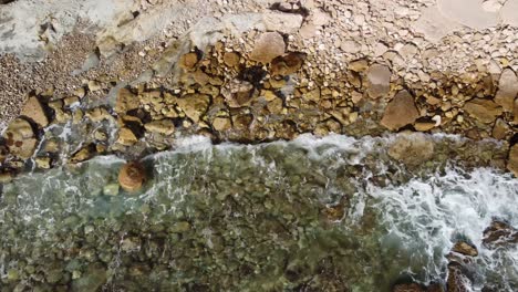 Luftaufnahme-Einer-Drohne,-Blick-Aus-Der-Vogelperspektive-Auf-Die-Felsige-Mittelmeerküste-In-Calpe,-Spanien:-Wellen-Brechen-Sich-Im-Kristallklaren-Wasser