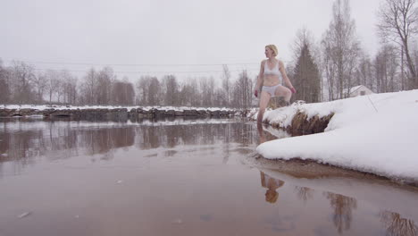 An-experienced-ice-bathing-woman-in-her-40s-enters-a-cold-lake