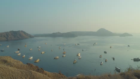 Many-boats-anchored-in-bay-of-Padar-island,-Indonesia