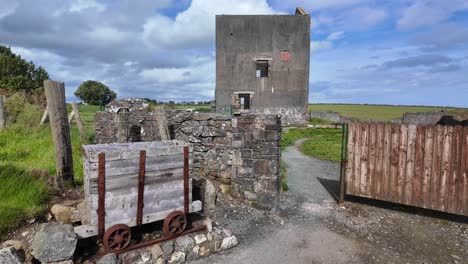 Historic-industrial-building-Tankardstown-Copper-Coast-Waterford-Ireland-with-cart-from-the-mines-tourist-attraction-on-a-scenic-coastal-drive