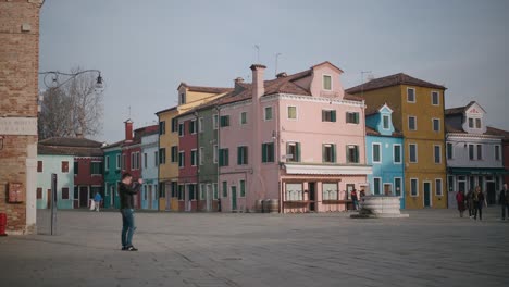 Tourists-walking-in-Burano-streets-between-colorful-houses
