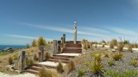 Una-Estatua-Maorí-Del-Jefe-Tuteurutira-Se-Encuentra-En-La-Cima-De-Una-Colina-Con-Vistas-Al-Océano-Pacífico