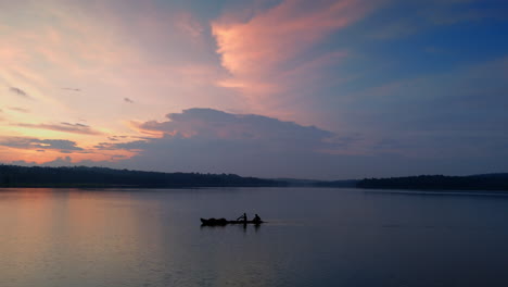 Morning-calm-lake-a-boat-is-flowing-the-surfaces-,-cloudy-morning-and-lake-reflecting-the-atmospheric-effects-of-the-sky