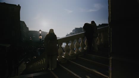 Silhouettes-on-Rialto-Bridge-at-sunset,-Venice-Italy