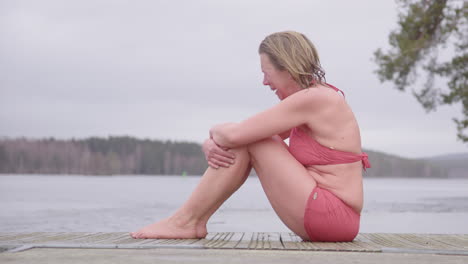 Emotional-woman-in-swimwear-sitting-on-pontoon-cries-after-cold-water-immersion