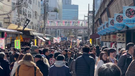 Menschenmassen-Laufen-Unter-Der-Brücke-Und-Den-Geschäften-Des-Tsukiji-Fischmarkts,-Tokio,-Japan