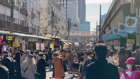 Turistas-Observando-La-Multitud-En-El-Mercado-De-Pescado-De-Tsukiji,-Tokio,-Japón